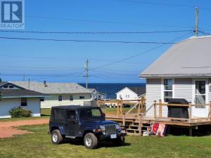 une jeep bleue garée devant une maison dans l'établissement Little Haven Cottage an ocean view 2 bedroom cottage in Savage Harbour, à Mount Stewart