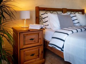 a bedroom with a bed and a night stand with a lamp at Moonshine Villa in Nadur