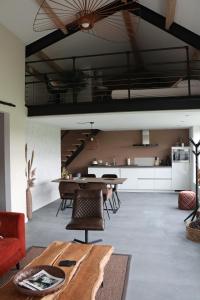 een woonkamer met een tafel en een keuken bij Met de Kippen op Stok - Vakantiehuisjes in Baexem