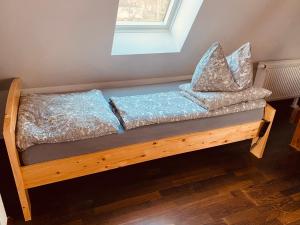 ein Holzbett mit Kissen darauf in einem Zimmer in der Unterkunft Moderne Wohnung im Grünen in Werneuchen