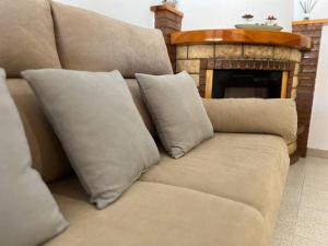 eine braune Couch mit Kissen vor dem Kamin in der Unterkunft Acogedor apartamento a escasos metros de la playa in Santa Pola
