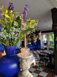 een blauwe vaas gevuld met bloemen op een tafel bij Logement Hellevoetsluis in Hellevoetsluis