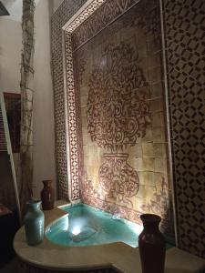 a pool of water in a room with vases at riad rose eternelle in Marrakech