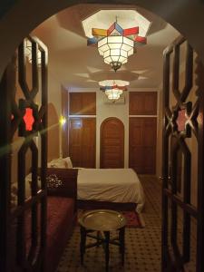 a bedroom with a bed and a chandelier at riad rose eternelle in Marrakesh
