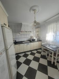 una cocina con suelo a cuadros en blanco y negro en Casa iluminada en pueblo tranquilo, en Jedula