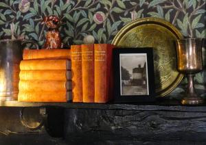 a group of books on a table with a picture and a glass at Ye Olde Smugglers Inne in Alfriston