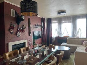 uma sala de estar com uma mesa de vidro e cadeiras em Top of the Mountain Гранд Манастира частни Апартаменти em Pamporovo