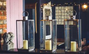 Trois bougies sur une table avec une statue et un miroir dans l'établissement Ye Olde Smugglers Inne, à Alfriston