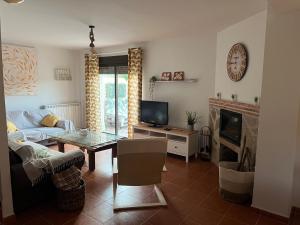 salon z kanapą, stołem i telewizorem w obiekcie Encanto - Pinilla del Valle w mieście Pinilla del Valle