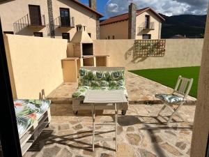 une terrasse avec un canapé, une table et des chaises dans l'établissement Encanto - Pinilla del Valle, à Pinilla del Valle