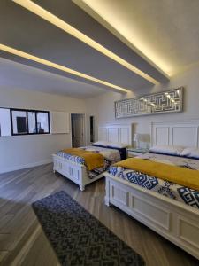 Habitación grande con 2 camas y suelo de madera. en Casa Escamela Suites privadas en Orizaba