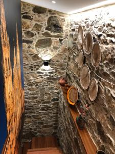 a room with a stone wall with plates on the wall at A Caseta, en plena Costa da Morte in A Coruña