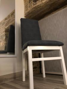拉科魯尼亞的住宿－A Caseta，房间里的一张黑座椅上的白色凳子