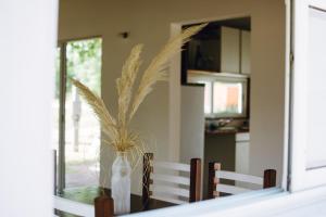 a dining room table with a vase with a plant in it at Descanso en La Caleta in Mar de Cobo +5 photos