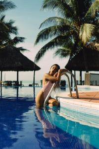a woman in a bikini sitting in a swimming pool at HOTEL UTZTZABA in Monterrico