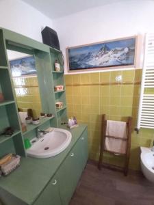 a bathroom with a sink and a toilet and a mirror at Appartamento raccolto con terrazzo e parcheggio in Antey-Saint-André