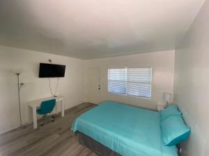 a bedroom with a bed and a desk and a television at Uptown Inn & Suites in St. Petersburg