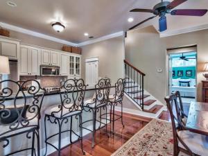 a kitchen with white cabinets and a table with chairs at Southern Grounds in Santa Rosa Beach