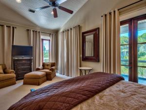a bedroom with a large bed and a television at Southern Grounds in Santa Rosa Beach