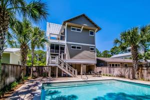 a house with a swimming pool and palm trees at Southern Grounds in Santa Rosa Beach