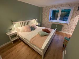 ein Schlafzimmer mit einem weißen Bett, einem Fenster und einem Holzboden in der Unterkunft Bed n Riesling in Forst