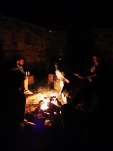 Un groupe de gens assis autour d'un feu la nuit dans l'établissement Cottage Prameny, à Prameny