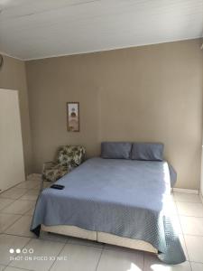 1 dormitorio con 1 cama azul y 1 silla en Loft's Rio en Aracajú