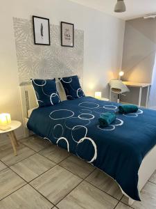 - une chambre dotée d'un lit bleu avec des draps bleus et des oreillers bleus dans l'établissement Le cosy en cœur de ville, à Prades