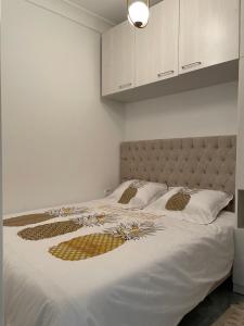 拉馬薩的住宿－LA PETITE PERLE A MARSA PLAGE，一间卧室配有带白色床单和金色枕头的床。