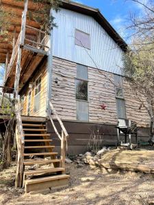 una casa con una escalera que conduce a ella en The Cedar House at Creekside Camp & Cabins, en Marble Falls
