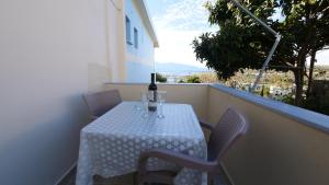 a table with a bottle of wine on a balcony at Kiri S.Apartaments in Sarandë