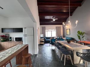 a kitchen and living room with a table and chairs at AeK Locações Casa Praia in Peruíbe