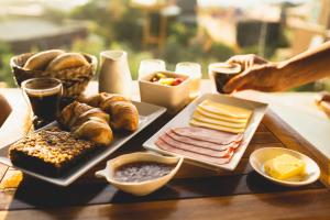 a table topped with different types of bread and other foods at Pichilemu Domos in Pichilemu
