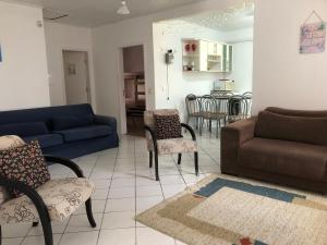 uma sala de estar com um sofá, cadeiras e uma mesa em CocoFloripa Hostel em Florianópolis