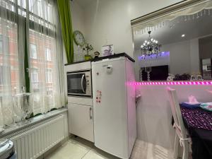 uma cozinha com um frigorífico branco e uma janela em Appartement centre Zaza em Bruxelas