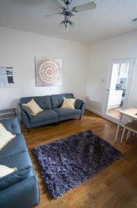 納尼頓的住宿－Comfortable equipped House in Nuneaton sleeps5 with FREE parking，客厅配有蓝色的沙发和桌子