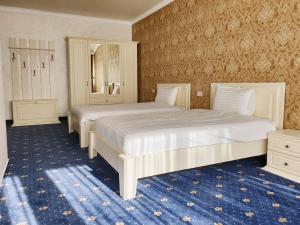 um quarto com 2 camas e um tapete azul em Hotel Bacsoridana em Tecuci