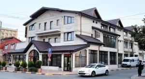 a white car parked in front of a building at Hotel Bacsoridana in Tecuci