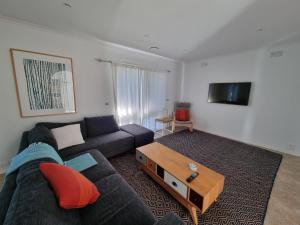 a living room with a couch and a coffee table at Tussock Sands in Point Lonsdale