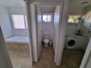 a bathroom with a tub and a toilet and a sink at Tussock Sands in Point Lonsdale