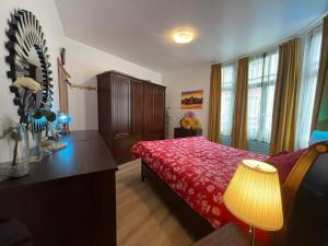 Appartement centre Zaza في بروكسل: غرفة نوم بسرير ولحاف احمر