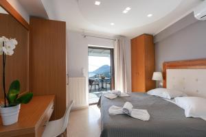 a bedroom with a bed and a desk and a window at AnnaView Apartments & Suites in Plakias