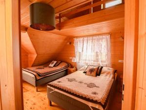a bedroom with two beds in a wooden cabin at Rezydencja Nosal in Zakopane