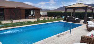 a swimming pool in a backyard with a gazebo at MANUIA in Coquimbo