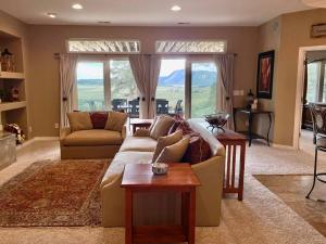 uma sala de estar com um sofá e uma mesa em Mountain Luxury & Views Galore Near Palmer Lake em Larkspur