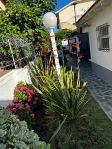 a lamp post in a garden with pink flowers at PH a 1 cuadra de la playa, 2 amb, patio y parrilla in Villa Gesell