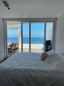 a bedroom with a bed with a view of the ocean at Descanso frente al mar in Viña del Mar