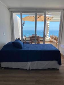 a bed in a bedroom with a view of the ocean at Descanso frente al mar in Viña del Mar