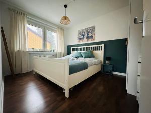 1 dormitorio con cama blanca y ventana en FeWo Ruhrnatur „Modern trifft Gemütlichkeit“ en Mülheim an der Ruhr