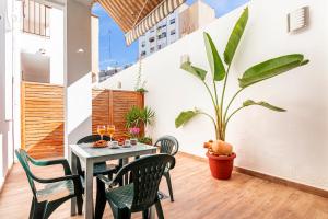 uma sala de jantar com uma mesa e cadeiras e um vaso de plantas em Flats Piera Valencia Center em Valência